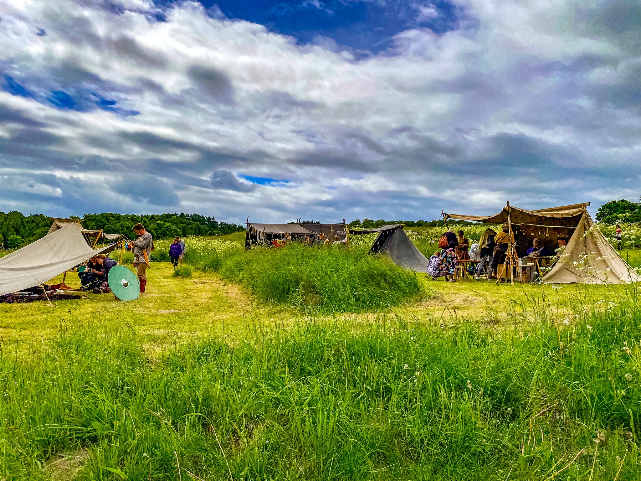 Telte med jernalderhåndværkere på græsmark